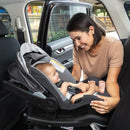 Load image into gallery viewer, A mom is placing her child in the Baby Trend EZ-Lift PRO Infant Car Seat