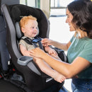 Load image into gallery viewer, A mom is placing her child in the Baby Trend Trooper SLIM 3-in-1 Convertible Car Seat