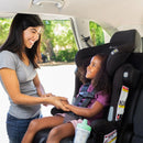 Load image into gallery viewer, A mom is placing her child into the Baby Trend Hybrid Combination Booster Car Seat