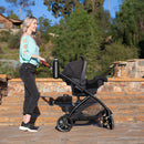 Load image into gallery viewer, A mom is pushing her baby in the Baby Trend Passport Switch 6-in-1 Modular Stroller