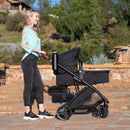 Load image into gallery viewer, A mom is pushing her baby in the Baby Trend Passport Switch 6-in-1 Modular Stroller