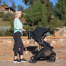 Load image into gallery viewer, A mom is pushing her baby in the Baby Trend Passport Switch 6-in-1 Modular Stroller