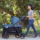 Load image into gallery viewer, Mom is pushing her two children in the Baby Trend Navigator 2-in-1 Stroller Wagon