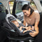 A mom is placing her child in the Baby Trend EZ-Lift PRO Infant Car Seat