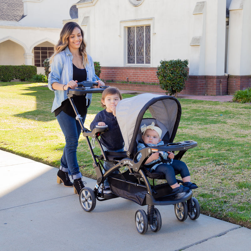 Mom is out door with her children in the Baby Trend Sit N' Stand Ultra Stroller