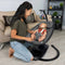 A mom is looking after her child while sitting in the Baby Trend NuMotion Infinity Swing