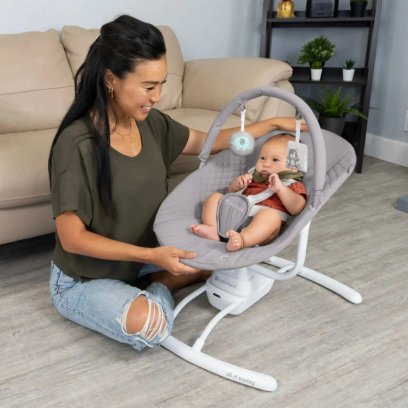A mom is watching her child sit in the Baby Trend Sit N' Sway Portable Swing