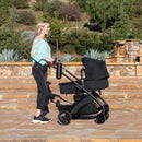 Load image into gallery viewer, A mom is pushing her baby in the Baby Trend Passport Switch 6-in-1 Modular Stroller 