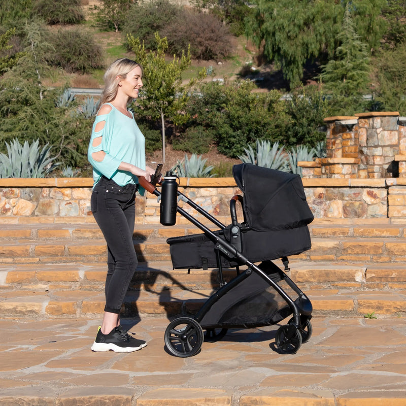 A mom is pushing her baby in the Baby Trend Passport Switch 6-in-1 Modular Stroller 