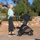 Load image into gallery viewer, A mom is pushing her baby in the Baby Trend Passport Switch 6-in-1 Modular Stroller 