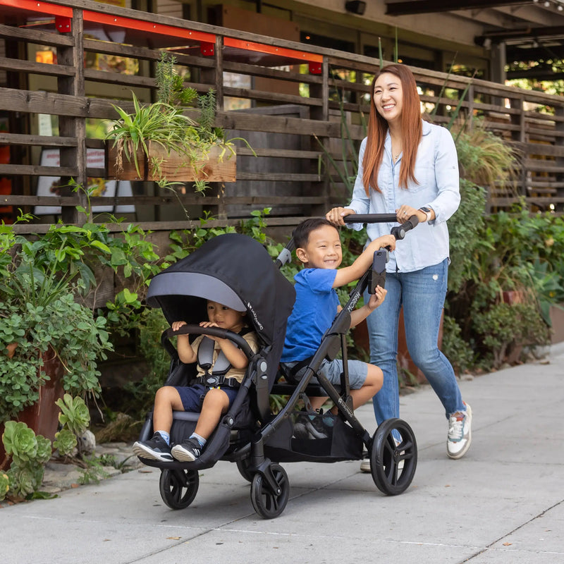 Mom and her two kids strolling outdoor with the Baby Trend Morph Single to Double Modular Stroller Travel System