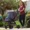 Mom strolling outdoor with her child in the Passport Carriage Stroller by Baby Trend