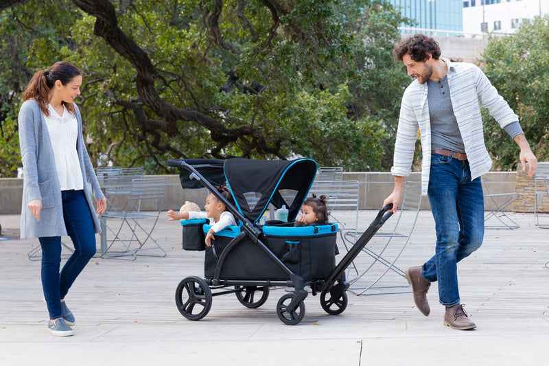 Dad is pulling his kids in the Baby Trend Expedition 2-in-1 Stroller Wagon PLUS 