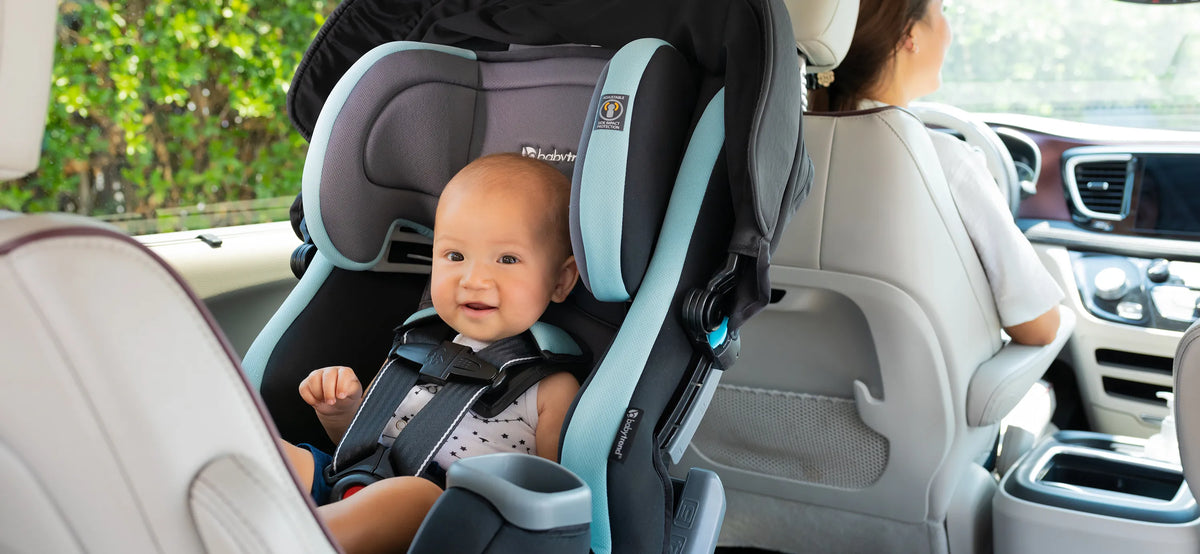 A child is sitting in the Cover Me Convertible Car Seat while the mom drive