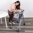 Load image into gallery viewer, Mom is feeding her child sitting on the Baby Trend Sit Right 2.0 3-in-1 High Chair