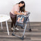 Mom is feeding her child sitting on the Baby Trend Sit Right 2.0 3-in-1 High Chair