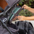 Load image into gallery viewer, A parent pulling open the cargo compartment on the back seat from the Baby Trend Sonar Cargo 3-Wheel Stroller Travel System