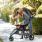 Mom looking over her child outdoor in the Baby Trend EZ Ride Stroller Travel System with EZ-Lift 35 Infant Car Seat