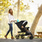 Mom is strolling her child outdoor at the park with the Baby Trend EZ Ride PLUS Stroller Travel System